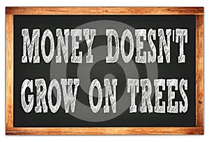 MONEY DOESN`T GROW ON TREES words on black wooden frame school blackboard