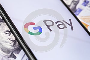 Money, dollars and smartphone with Google Pay logo on the screen