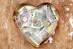 Peníze dar a spoření v srdce krabice 
