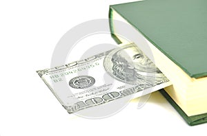 Money embedded in a book on a white background close-up