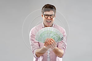 Happy young man in glasses with fan of euro money