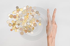 Money and Finance Topic: Money coins and human hand showing gesture on a gray background in studio top view