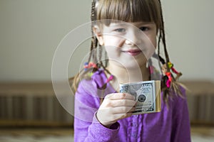 Money, finances and people concept - smiling little girl with dollar cash money.