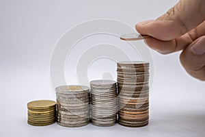 Money, Financial, Business Growth concept, Close up of hand man holding and put coin to top of stack of coins