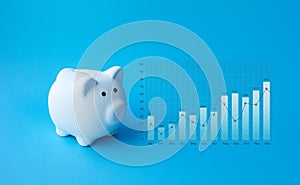 Money and financial concepts with piggy bank and business graph growth on blue background