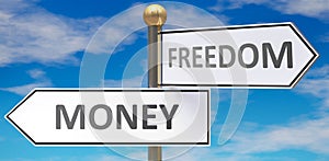 Money and freedom as different choices in life - pictured as words Money, freedom on road signs pointing at opposite ways to show
