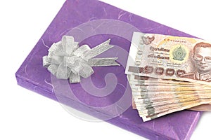 Money on gift box purple