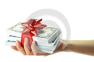 Money gift in a female hand, isolated on white transparent background, US dollars stack and red bow, festive present