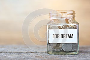 Money in a glass jar with `dream` word. concept