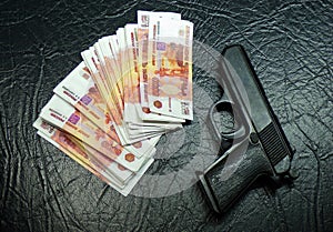 Money and a gun. A stack of stolen money with a gun.