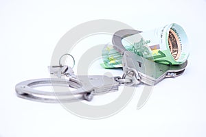 Money and handcuffs. Concept for corruption, fraud, money laundry, crime photo