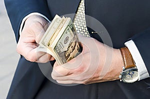 Money in hands close up. a man in a business suit counts American dollars. cash payment. repay debts. financial airbag photo