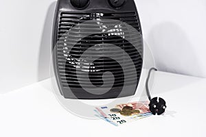 Money for heating bills with black heater on white background. Autumn season