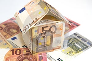 Money house made from euro banknotes on white background.