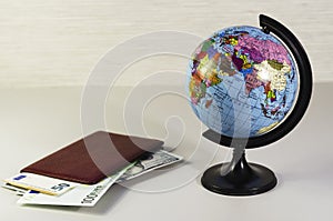Money inside passport and globe