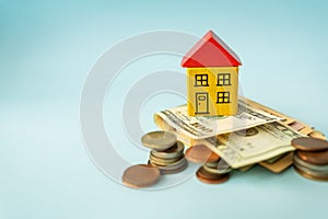 Money in international currency, including euro, dollar, a coin on which there is a toy house. The concept of mortgages,