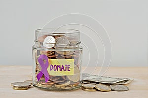 Money jar full of coins with violet ribbon and Donate label - Concept of Alzheimer, Pancreatic cancer, Epilepsy , Hodgkin`s