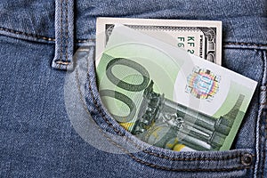 Money in jeans pocket - one hundred euro bill and one hundred dollar bill. Diversification concept.