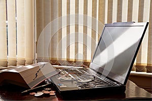 Money, laptop, pen, glasses a and book.