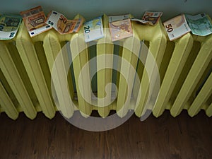 Money laundering concept image with copyspace. Euro banknotes drying on yellow radiator photo