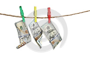 Money laundering. Dollar banknotes hanging on clothesline against white background