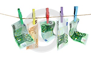 Money laundering. Euro banknotes hanging on clothesline against white background