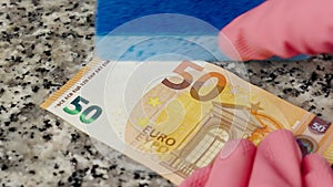 Money laundering by hands with protective gloves and sponge. Washing a fifty euro banknote