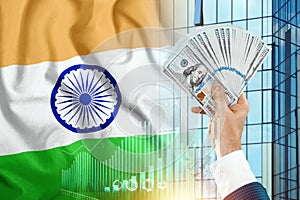 Money in a man`s hand against the background of the flag of India. Indians` Income. The financial condition of the inhabitants o