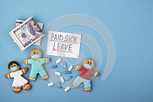 Money, medicine and a gingerbread family in a mask with the inscription paid sick leave