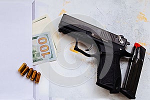 Money for murder. Black gun on American dollars background. Military industry, war, global arms trade, weapon sale, contract