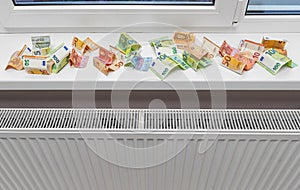 Money near the radiator. Expensive energy supply.