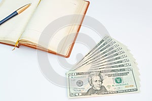 Money, notebook and pen with white background. Isolated