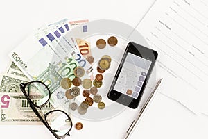 Money phone calculator pen paper and glasses on white background