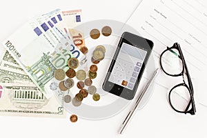 Money phone calculator pen paper and glasses on white background