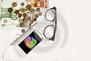 Money phone calculator pen paper and glasses on white background