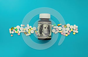 Money and pills of different colors on a blue background. The rise in the cost of medical care. The concept of insurance