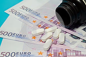 Money pills. Medicine pills on euro bills on a blue background. Covid-19 coronavirus pills are in euro money. The