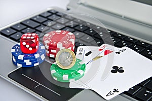 Money, playing cards, dice and casino chips on computer keyboard