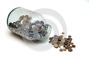 Money poured from a glass jar on a white background