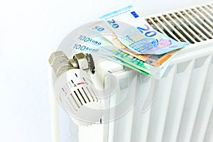 Money on a radiator symbolizes the expensive heating costs