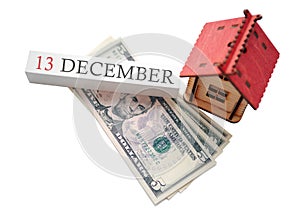 Money and red home with calendar. The concept of financial independence and the scheduled start date for December 13, winter