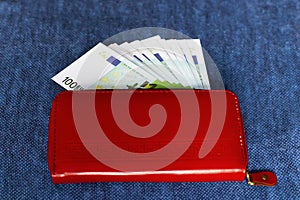 Money in a red purse on a blue background