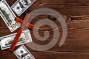 Money and religion. Wooden cross on dollars