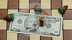 Money Rules: Pawns Lying Around A King Standing On A 10 Dollars Banknote