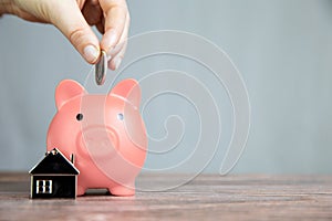 Money saving for buying a new house in pink piggy bank , real estate,mortgage,loans,business concept with space for text copy
