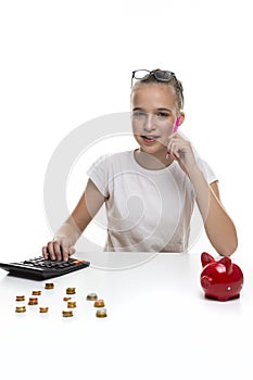 Money Saving Concepts. Teenager Blond Girl Posing With Coins and Moneybox. Calculating Income With Calculator For Savings