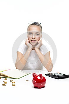 Money Saving Concepts. Teenager Blond Girl Posing With Coins and Moneybox. Calculating Income With Calculator For Savings. Focus