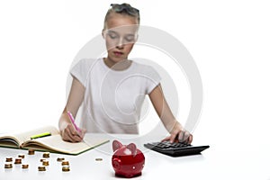 Money Saving Concepts. Teenager Blond Girl Posing With Coins and Moneybox. Calculating Income With Calculator For Savings. Focus