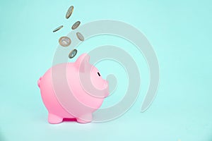 Money saving for future investment and retirement concept. concept theme with a pink piggy bank with falling coins