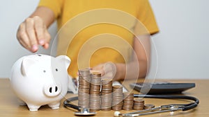 Money Saving, Health Insurance, Medical, Donation and Financial concepts. woman with coins stack and piggy bank and stethoscope,